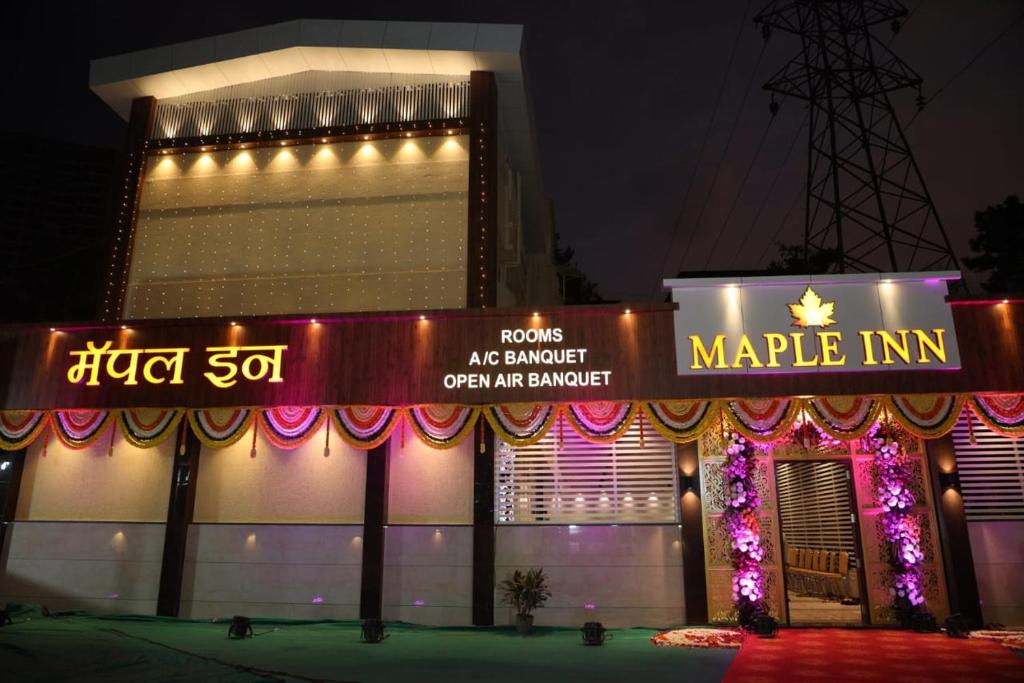 un edificio con un cartel que lee posada de mercado en Maple Inn en Thane