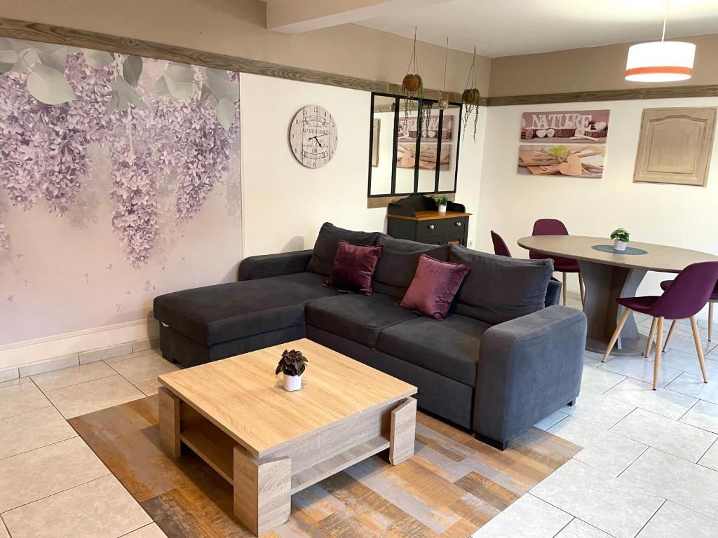 a living room with a couch and a table at La Maison des lilas, 5 mn de Beauval in Saint-Aignan