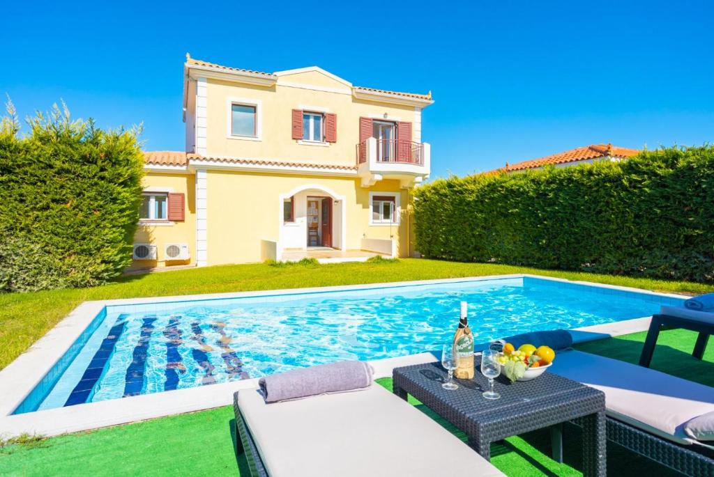 una villa con piscina di fronte a una casa di Villa Europe Thia a Fokáta