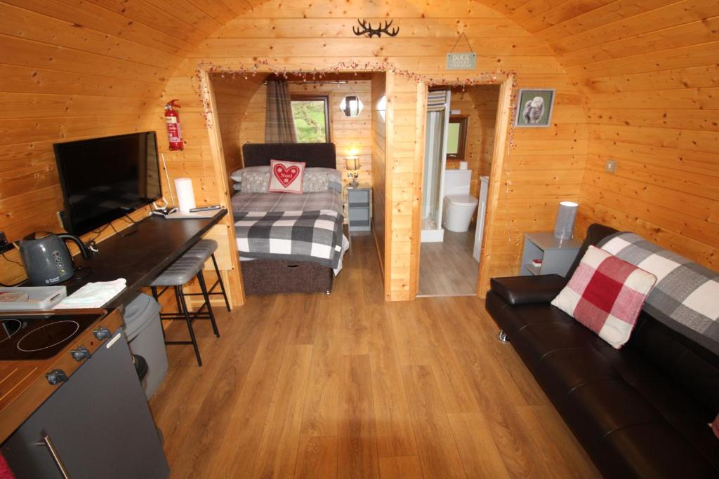 Habitación con cama y sofá en una cabaña en Carrock Pod, Hayton, en Brampton