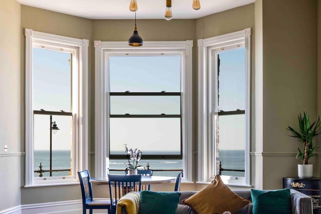 a living room with views of the ocean from windows at Beachfront Bolthole with Luxury, Style and Spectacular Sea Views in Herne Bay