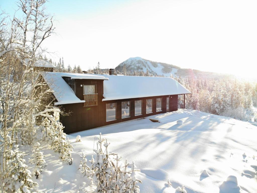 una casa ricoperta di neve in montagna di Tännäskröket a Tännäs