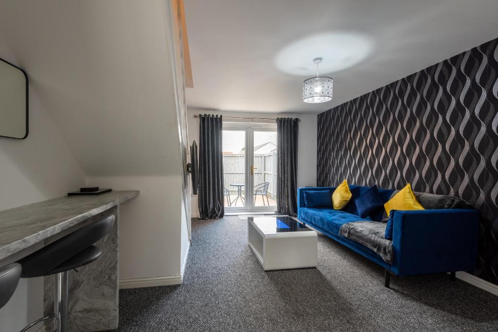 a living room with a blue couch with yellow pillows at Durham Gate View in Spennymoor