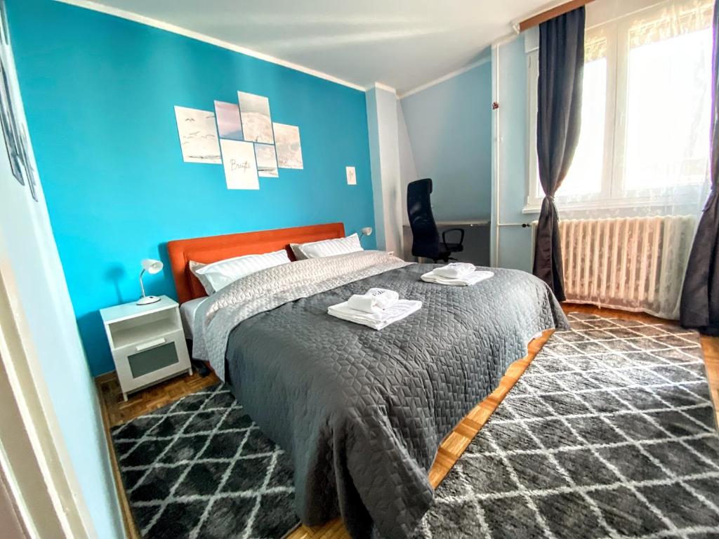 Un dormitorio con una cama y una pared azul. en Peti, en Belgrado