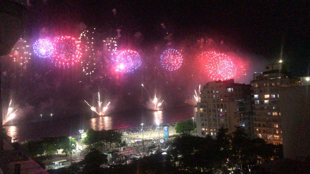 una pantalla de fuegos artificiales sobre un río en una ciudad por la noche en Copa Paradiso, en Río de Janeiro