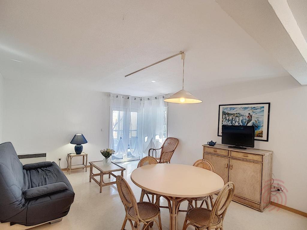 un salon avec une table et un canapé dans l'établissement Lamalo-les-Bains: F2, terrasse, 50m des Thermes, animaux acceptés - FR-1-451-23, à Lamalou-les-Bains