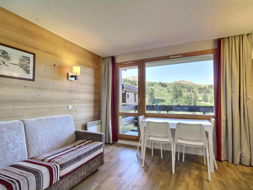 un salon avec un canapé, une table et des chaises dans l'établissement Appartement cosy sur les pistes avec balcon et WiFi - FR-1-455-1, à Belle Plagne