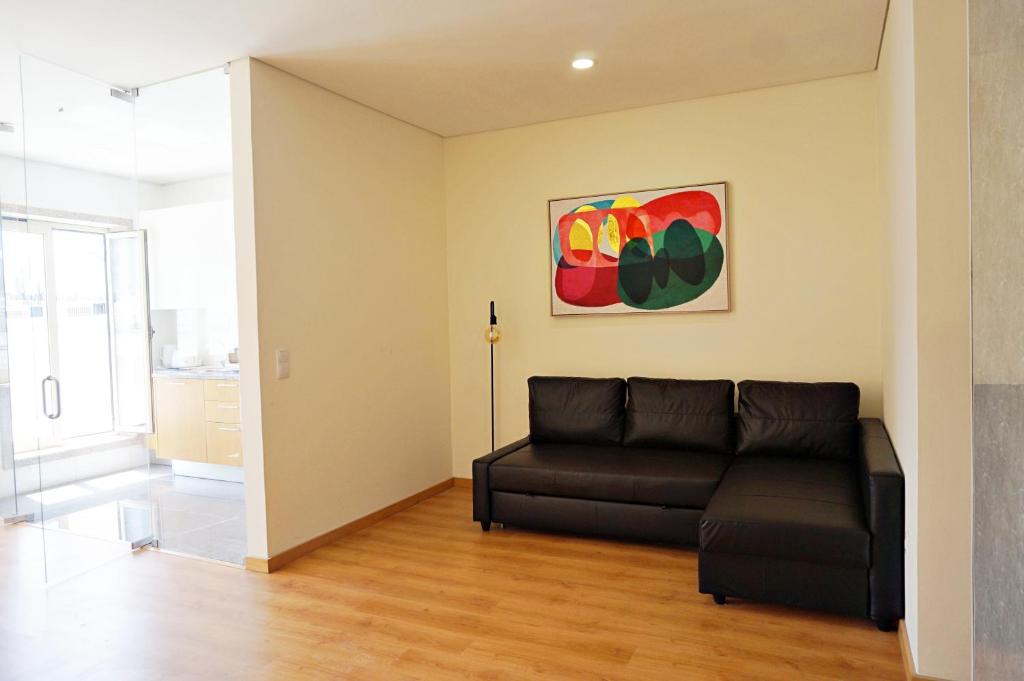 - un salon avec un canapé et un tableau mural dans l'établissement Tomás Flat, à Porto