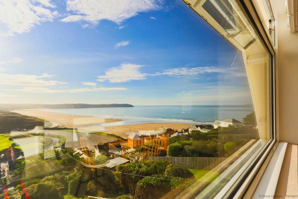 uma vista para a praia a partir de uma janela num hotel em WOOLACOMBE SUNNYSIDE APARTMENT 2 Bedrooms em Woolacombe