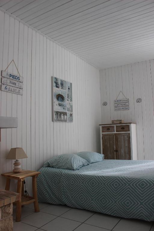 a bedroom with a bed and a wooden table at GITE AVEC SPA ENTRE FORET ET PLAGE - Ambiance Bord de Mer in Saint-Hilaire-de-Riez