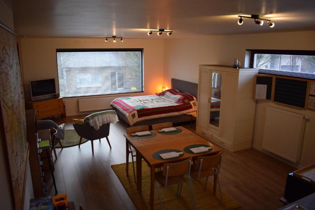 ein kleines Zimmer mit einem Bett, einem Tisch und Stühlen in der Unterkunft B&B Houten Huis in Nazareth