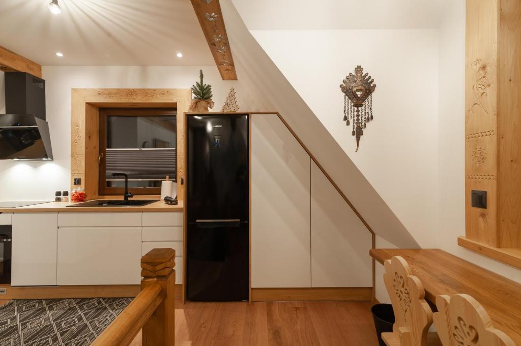 eine Küche mit einem schwarzen Kühlschrank und einer Treppe in der Unterkunft Oczko Na Giewont in Kościelisko