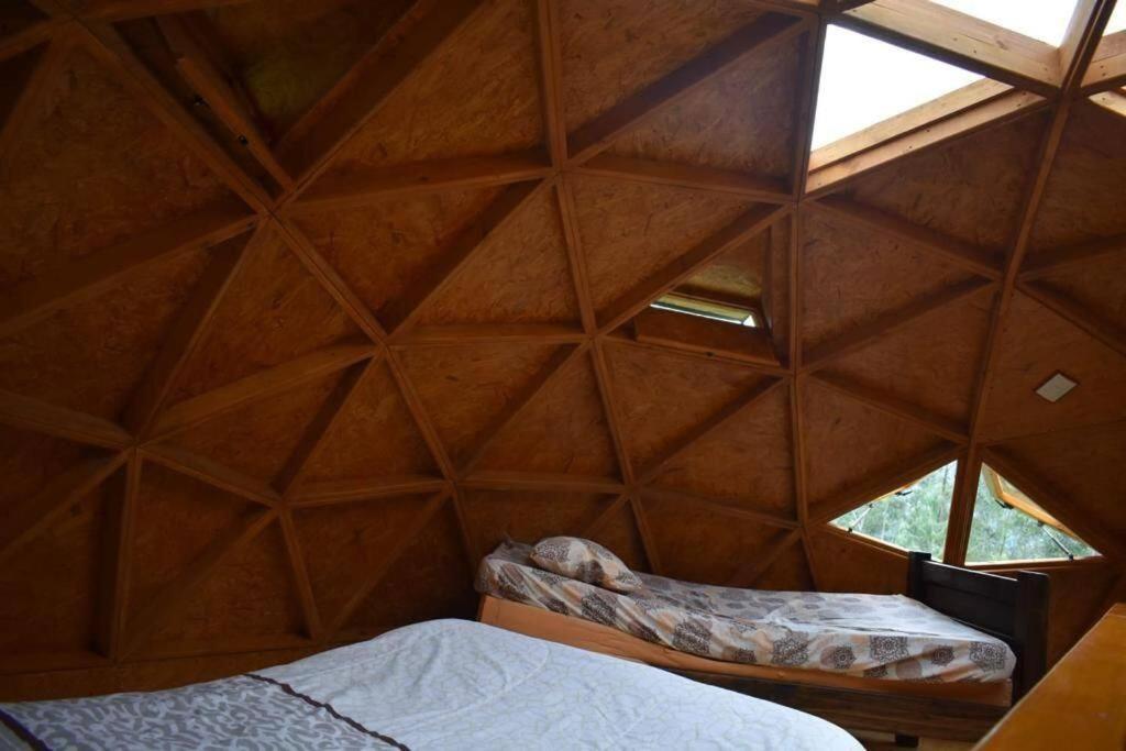 Habitación con techo de madera y cama. en cabaña tipo domo 100% equipado, en Nobsa