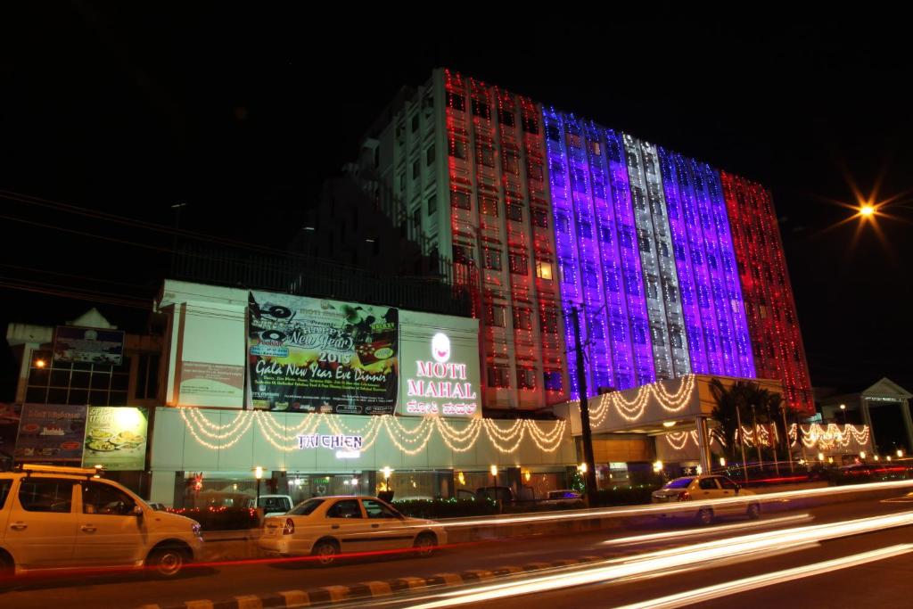 un edificio iluminado en azul y rojo por la noche en Moti Mahal, en Mangalore