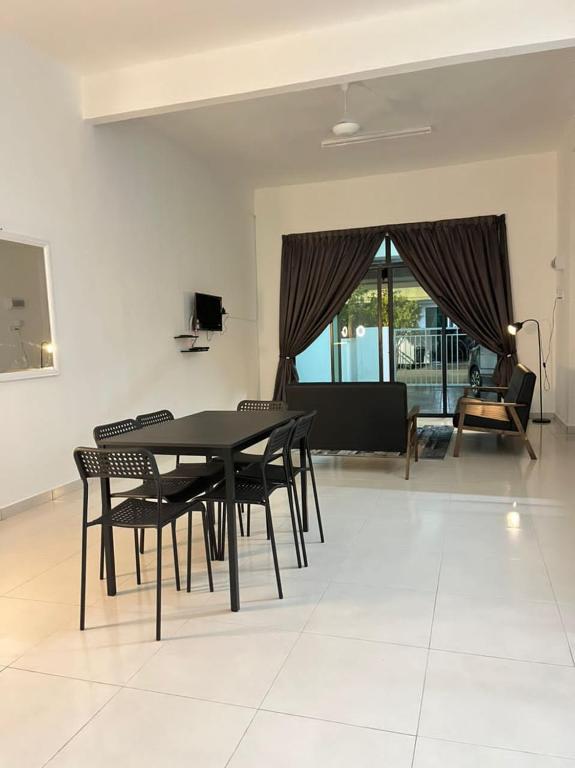 a dining room with a black table and chairs at Homestay Kemaman Fyna04 dekat Pantai Geliga in Kemaman