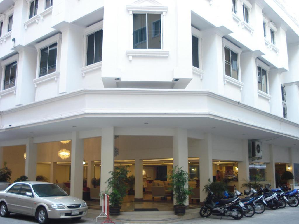 a white building with motorcycles parked in front of it at LK Mansion in Pattaya