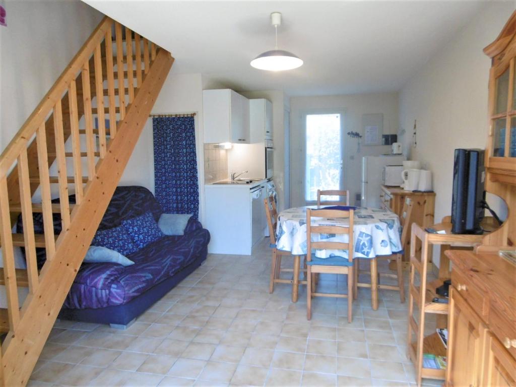 sala de estar con escalera, mesa y sofá en Maisonnette Youenn, en Sarzeau