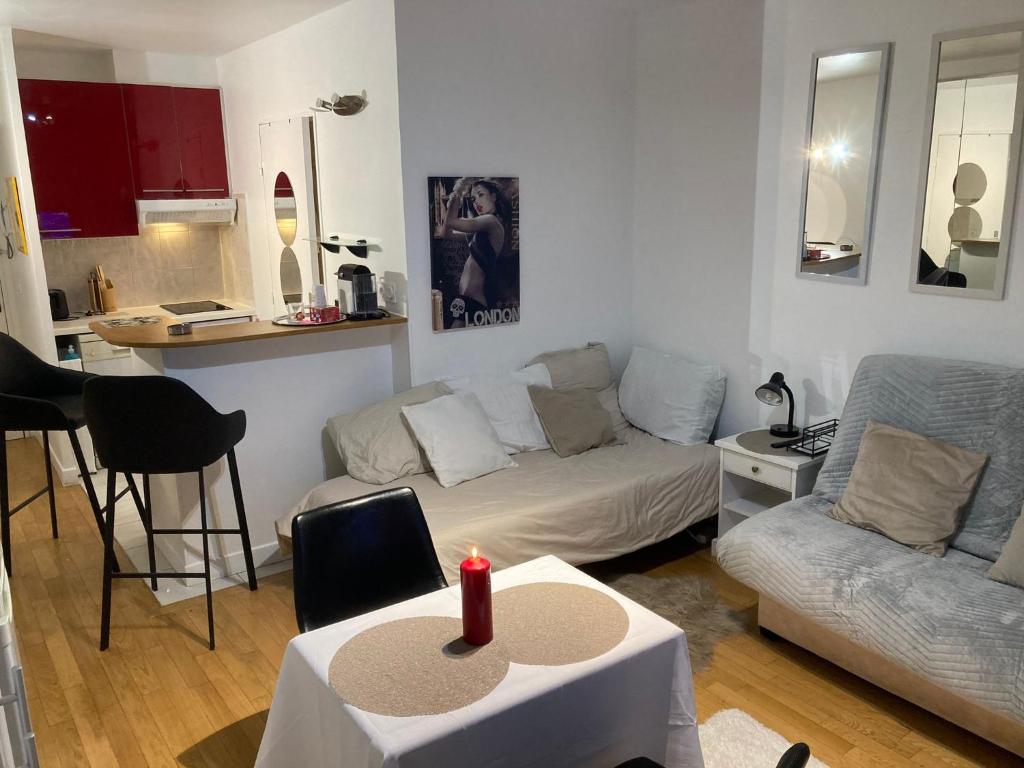 - un salon avec un canapé et une table avec une bougie dans l'établissement Studio calme et éclairé proche de Nation A, à Paris