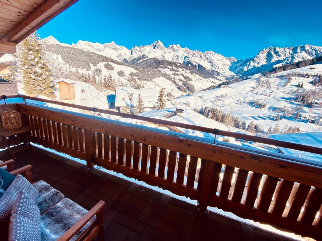 uma varanda com vista para as montanhas cobertas de neve em Ski-in & Ski-out out Chalet Maria with amazing mountain view em Maria Alm am Steinernen Meer