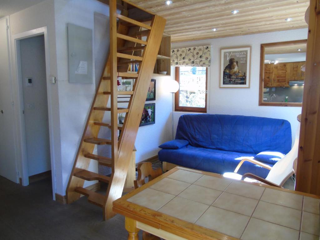a living room with a blue couch and a spiral staircase at Charmant Appartement avec Mezzanine et Balcon - 4-5 Pers., Garage, Proche Lac et Navette - FR-1-198-121 in Châtel