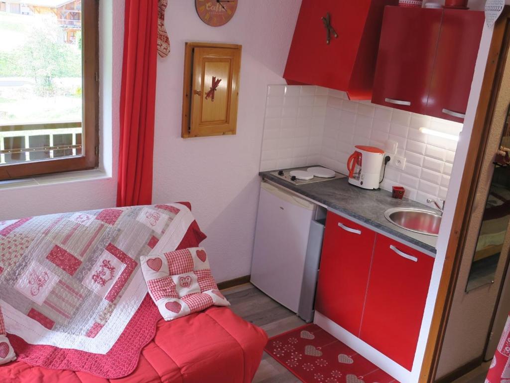 シャテルにあるStudio Châtel, 1 pièce, 4 personnes - FR-1-198-128の小さなキッチン(赤いキャビネット、赤いソファ付)