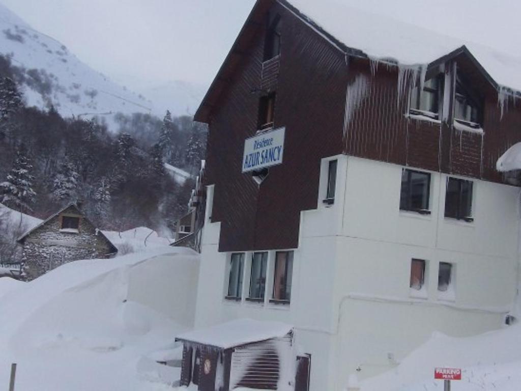 een gebouw met een bord in de sneeuw bij Appartement Mont-Dore, 2 pièces, 4 personnes - FR-1-415-8 in Le Mont-Dore