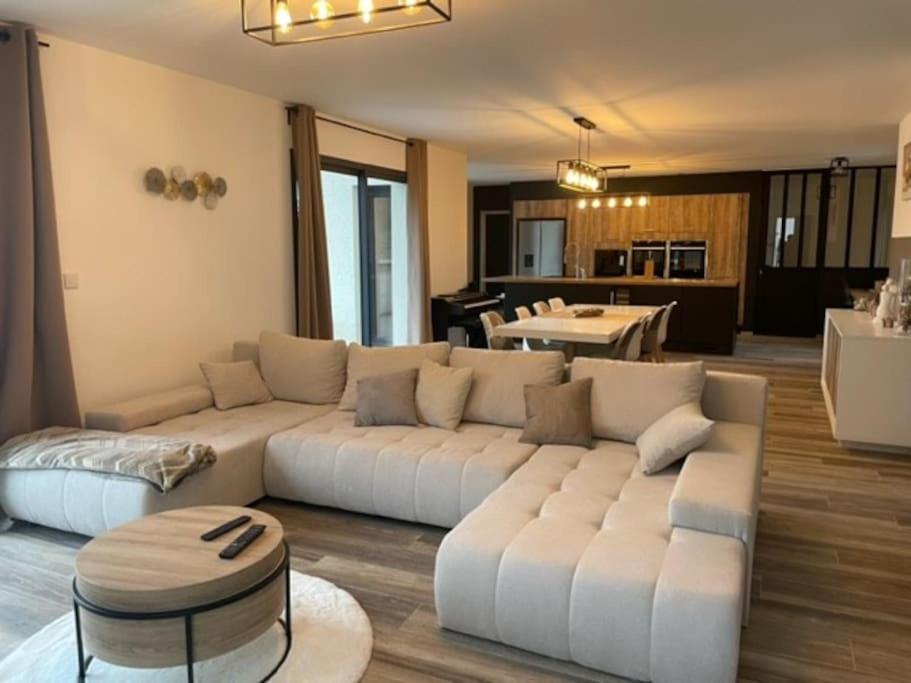 ein Wohnzimmer mit einem weißen Sofa und einer Küche in der Unterkunft Cassie Home in Saint-Jean-en-Royans