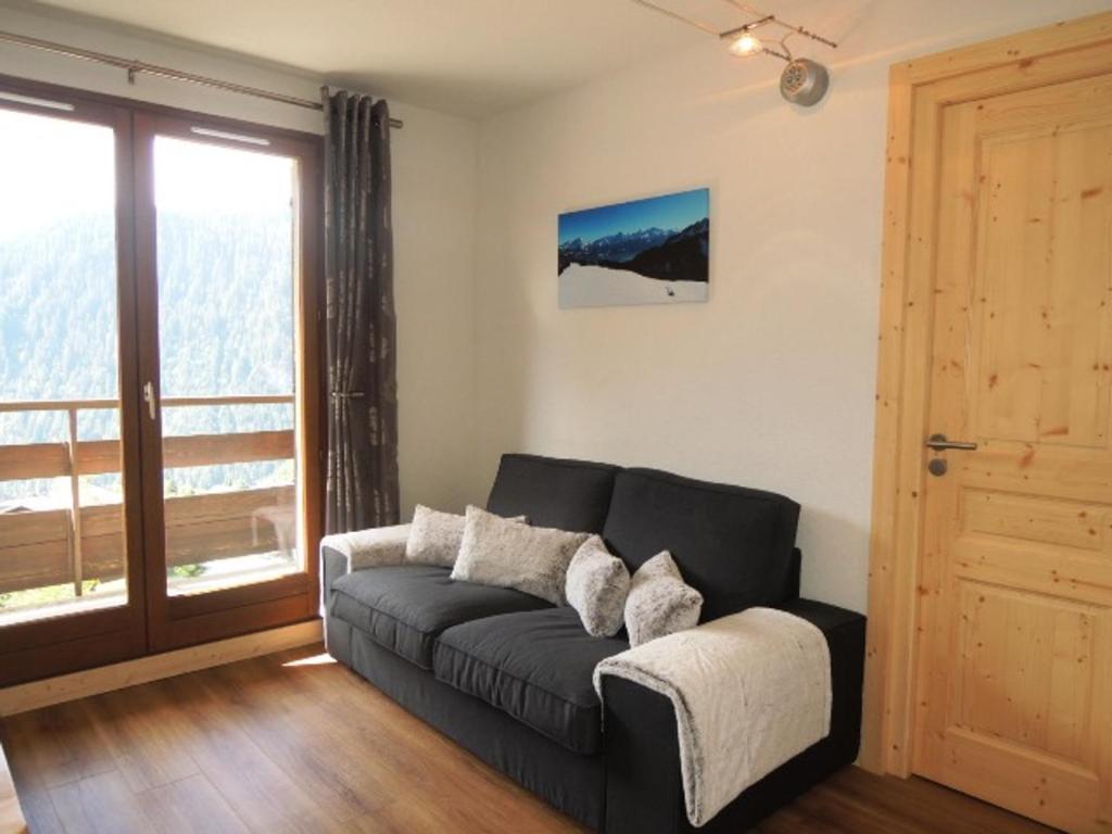 a living room with a couch and a large window at Appartement Châtel, 2 pièces, 4 personnes - FR-1-198-159 in Châtel