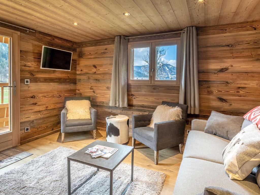 un salon avec un canapé, des chaises et une télévision dans l'établissement Chalet Chaleureux - 1 Ch - 4 Pers - Terrasse - Parking - FR-1-437-75, à La Clusaz