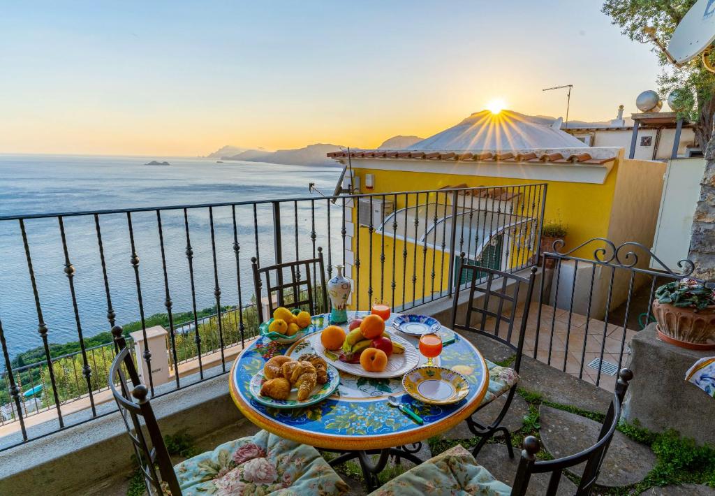 a table with a plate of food on a balcony at La Sovrana in Praiano