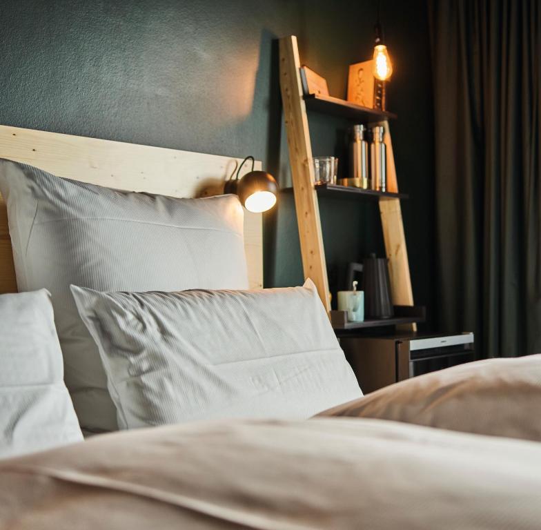 um quarto com uma cama com almofadas brancas e uma prateleira em Urban Nature St Peter-Ording em Sankt Peter-Ording