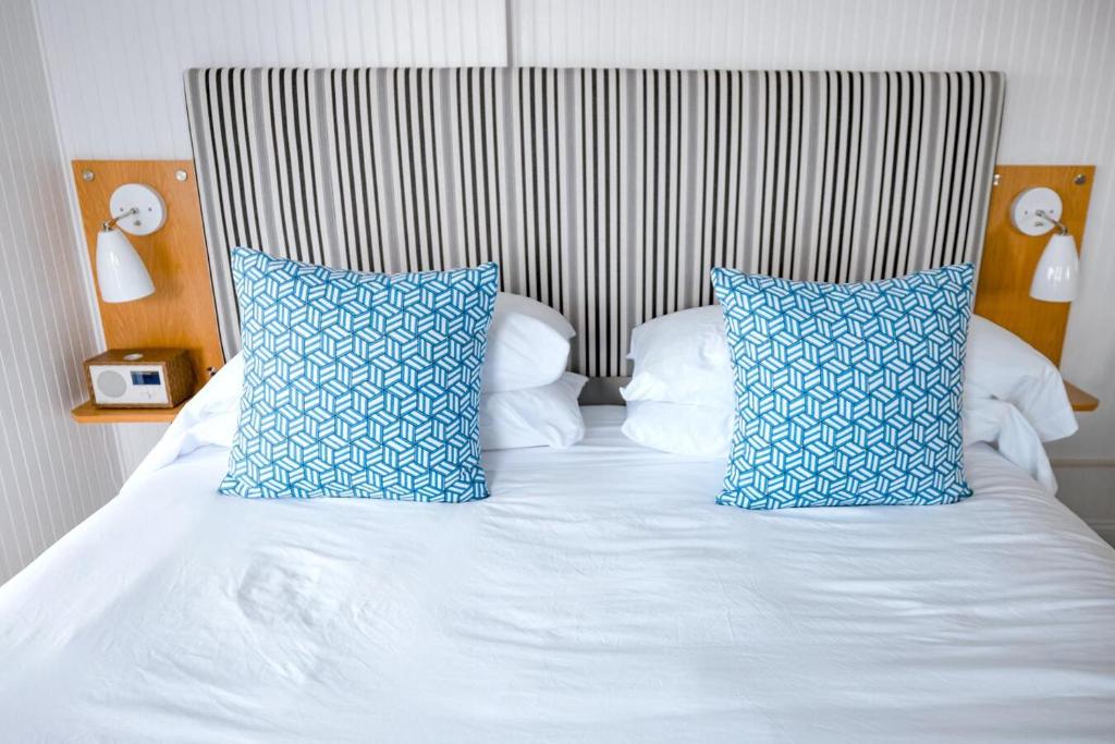 un letto con cuscini bianchi e blu di B&b Art Boutique a Mantova
