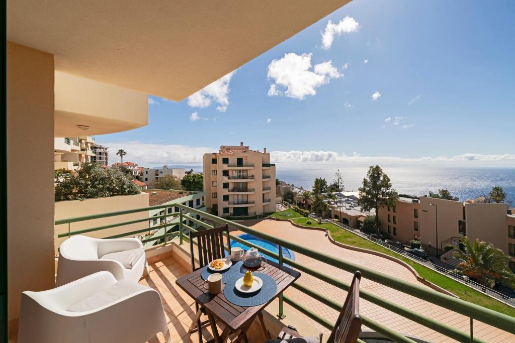 a balcony with a table and chairs and a view of the ocean at Garajau IV by An Island Apart in Caniço