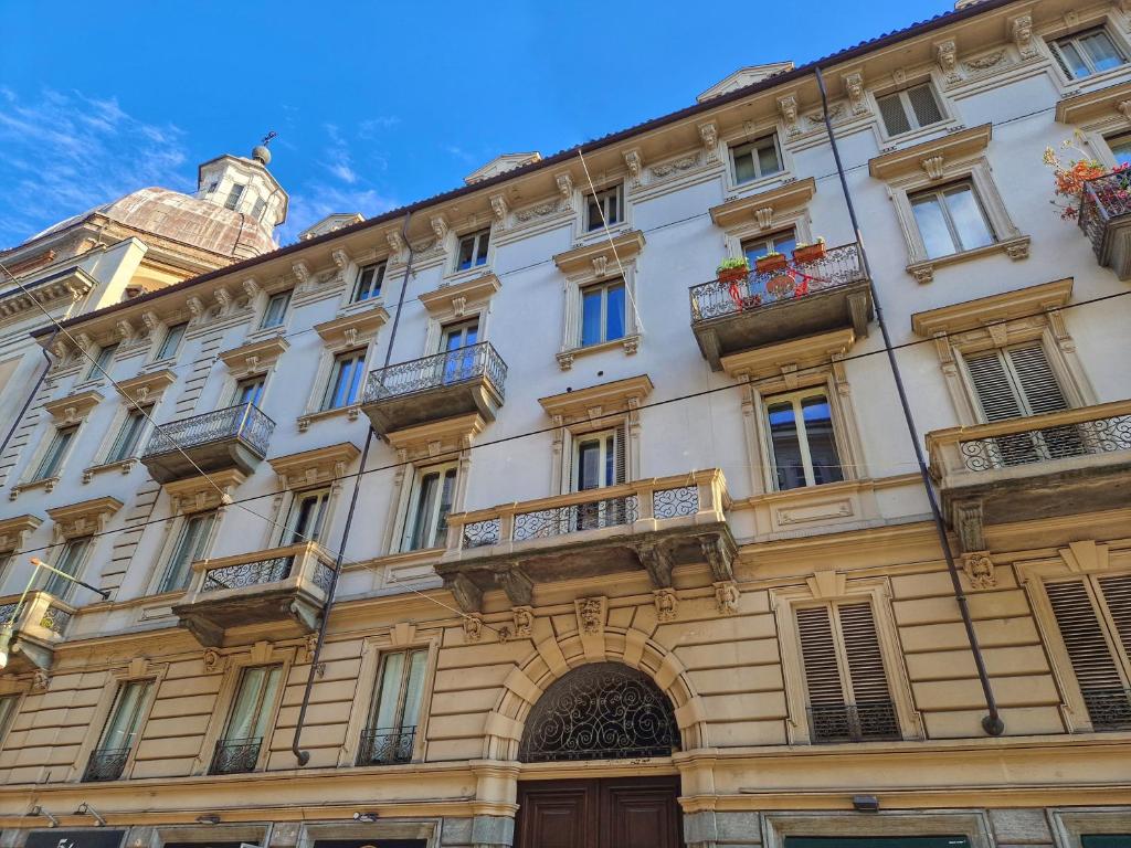 a large building with balconies and a clock tower at Ana's Place Torino 2 in Turin