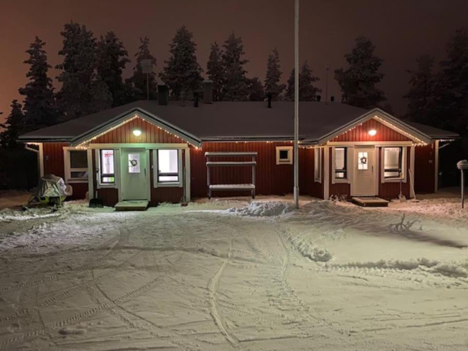 a house at night with snow in front of it at Seitapolku 12 Villa in Saariselka