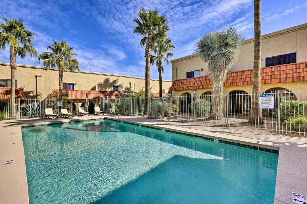 una piscina frente a un edificio con palmeras en Modern Fountain Hills Townhome with Private Patio!, en Fountain Hills