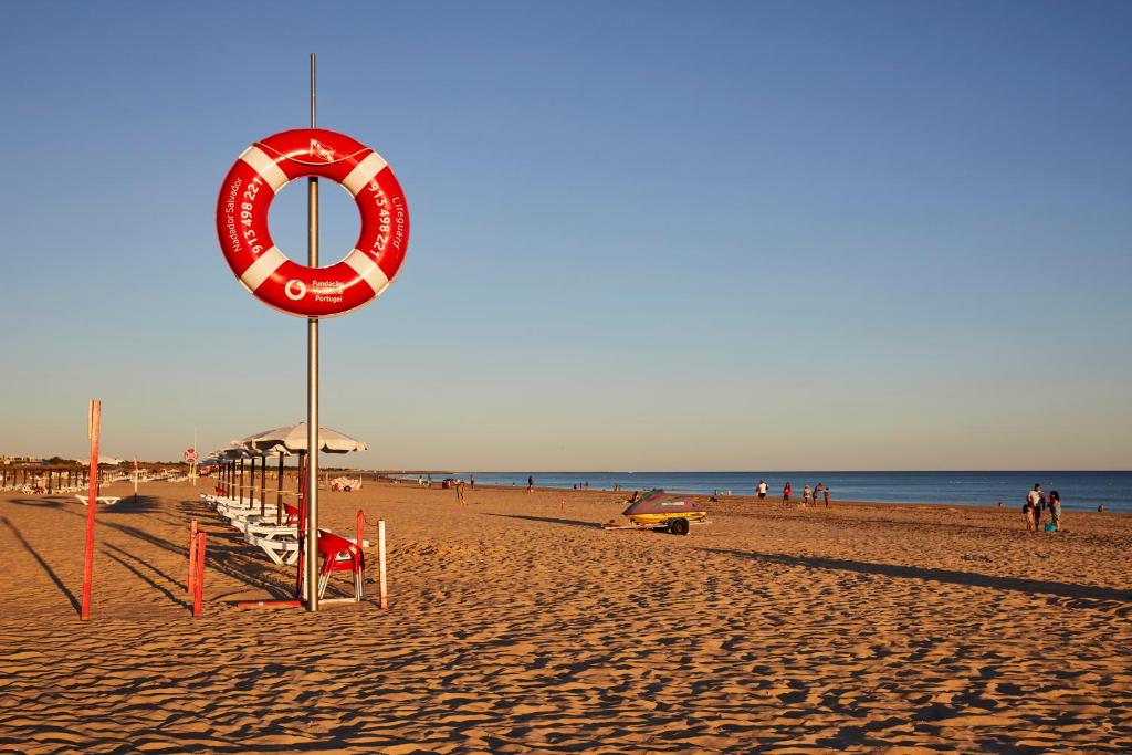 una playa con un letrero rojo y blanco en ella en Nice apartment near the beach - Monte Gordo en Monte Gordo
