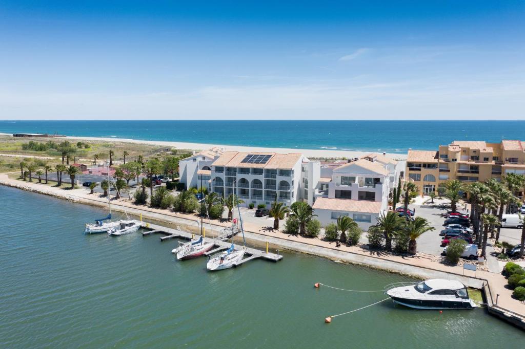 einen Yachthafen mit Booten im Wasser neben einem Strand in der Unterkunft Résidence Pierre & Vacances Les Bulles de Mer in Saint-Cyprien