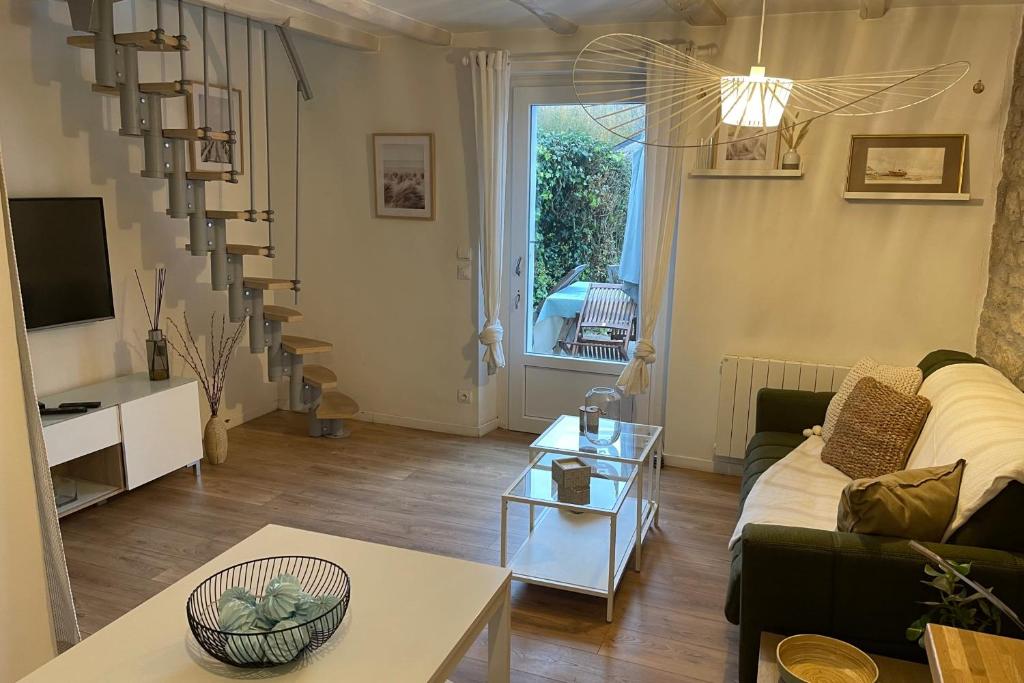 a living room with a couch and a table at Cosy's Kerguelen - Longère jardin in Larmor-Plage