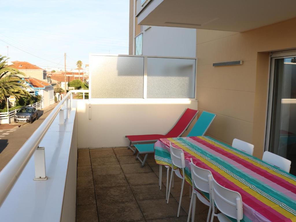 d'une table et de chaises colorées sur un balcon. dans l'établissement Duplex T4 à Arcachon: Terrasse, WiFi, Parking, à 150m de la Plage - FR-1-374-22, à Arcachon