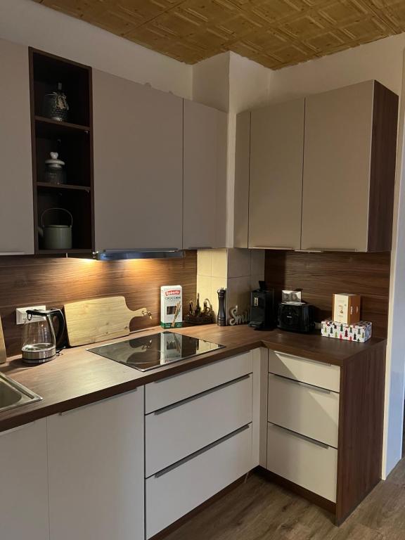 une cuisine avec des armoires blanches et un évier dans l'établissement Modernes Haus nähe Schloss Ulmerfeld, à Ulmerfeld