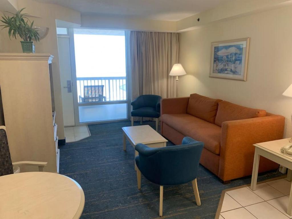 a living room with a couch and a table at Coastal Hideaway Oceanview Condo in Daytona Beach
