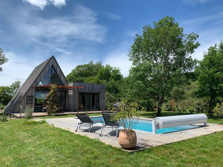 a house with a swimming pool and two chairs at Les Trigones du Causse -Maison atypique avec Piscine Privée in Saint-Martin-Labouval