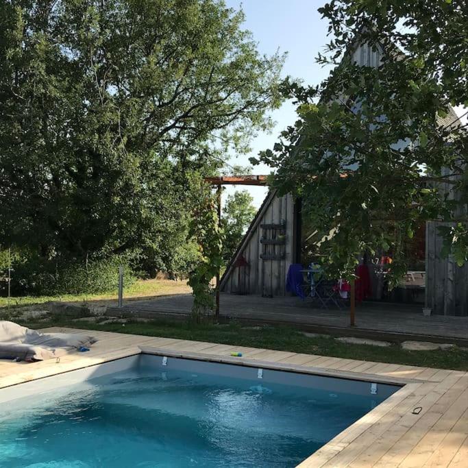 una piscina en un patio con una casa en Les Trigones du Causse -Maison atypique avec Piscine Privée, en Saint-Martin-Labouval