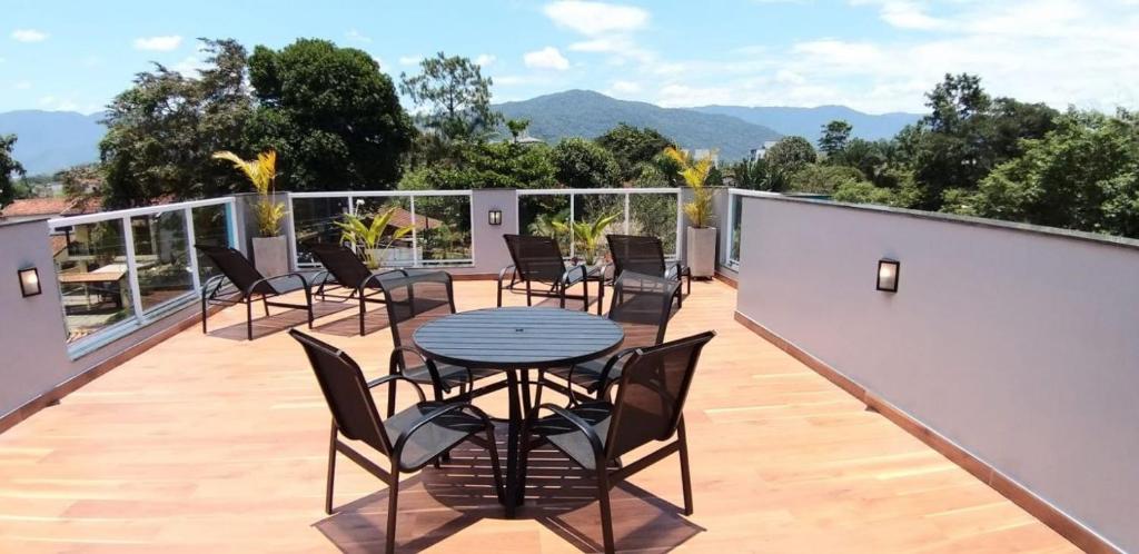 Un patio con sillas y una mesa en el balcón. en Solarium Flats Itagua - Ubatuba SP en Ubatuba