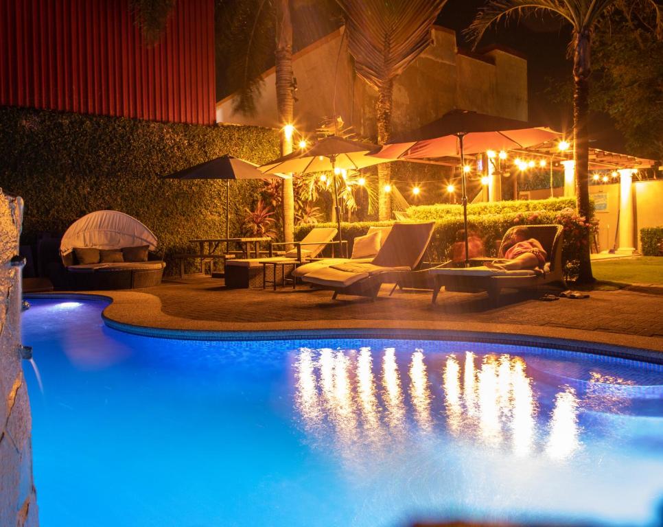 a swimming pool at night with lights and umbrellas at 12B Jaco Sol Quadplex in Jacó