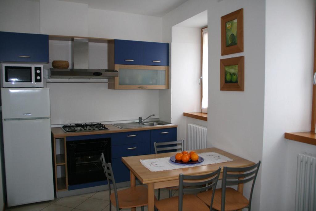 ピエトラムラタにあるCasa Elisaのキッチン(青いキャビネット、オレンジ付きのテーブル付)