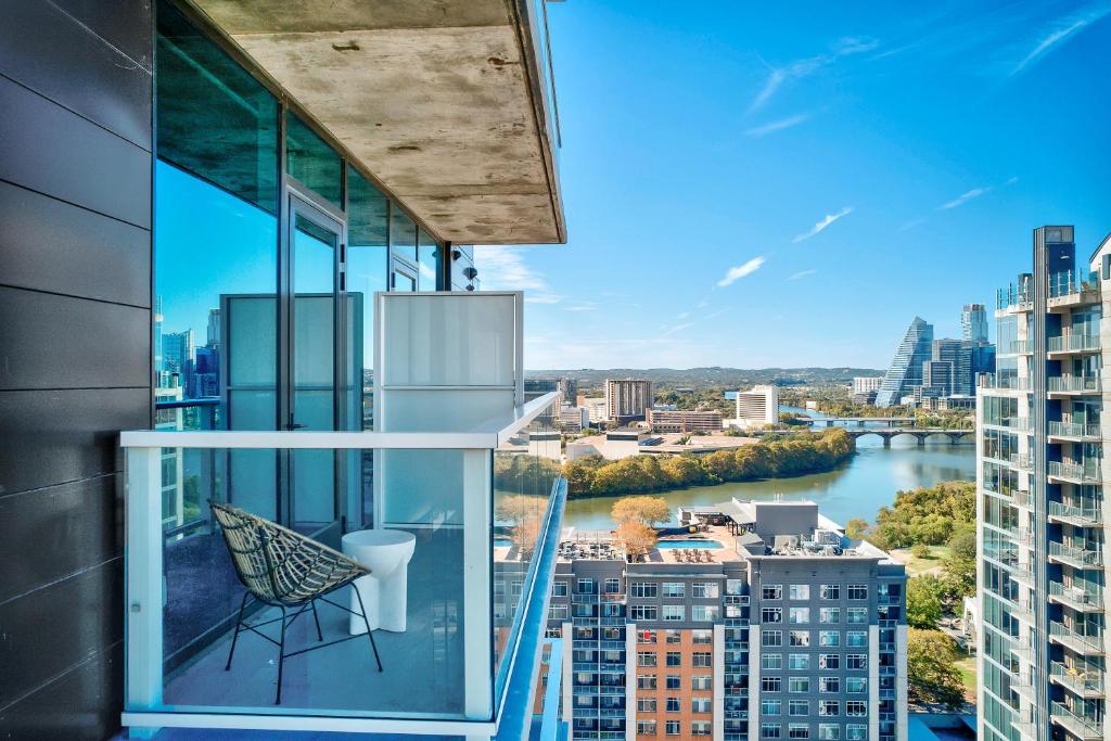 a balcony with a chair and a view of a city at Upscale Rainey St Condo Homes - Peloton, gym, rooftop pool, wifi included in Austin