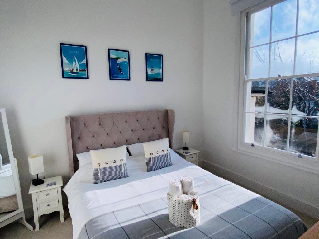 a bedroom with a bed with white sheets and a window at Wight On The Beach, Sleeps 4, Free Off Road Parking, Balcony with Sea Views in Ryde