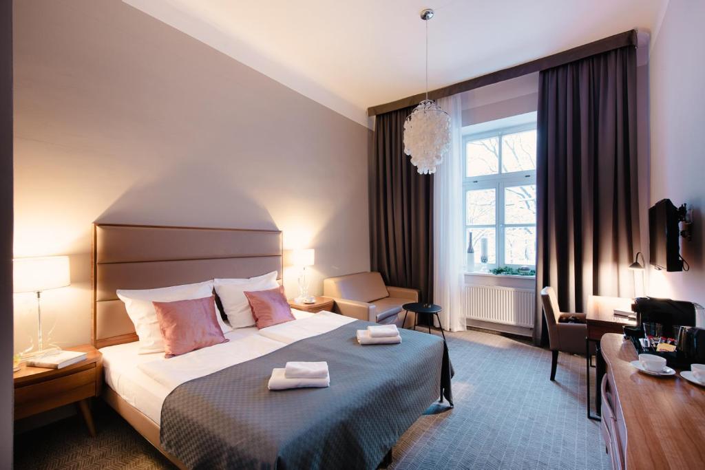 a hotel room with a bed with two towels on it at Aparthotel Old Town in Kraków